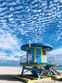 Lifeguard hut on beach against sky