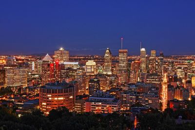 Illuminated buildings in city against sky at night