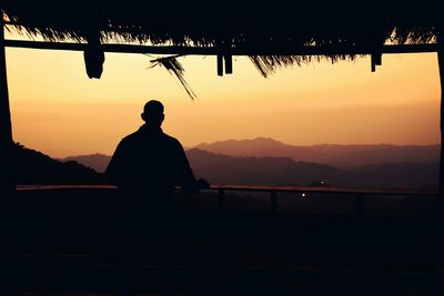 Silhouette of man looking at sunset