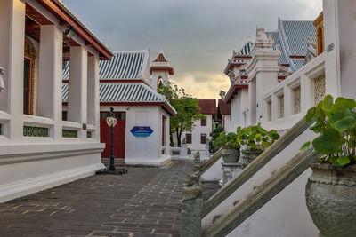 Houses by buildings in town against sky