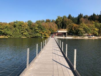 Pier over lake against clear sky