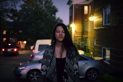 Portrait of young woman standing outdoors at night