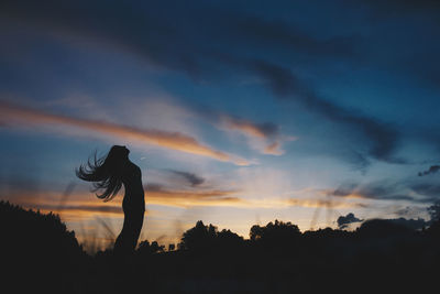 Silhouette of a woman against sky during sunset