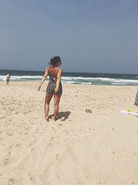 Rear view of woman standing on beach