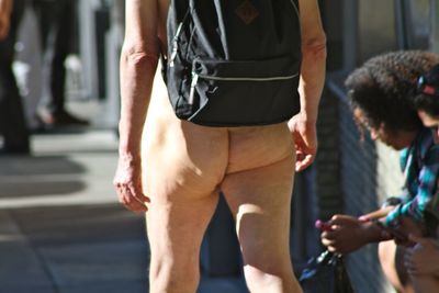 Rear view of people walking on street in city