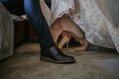 Man helping woman to put on high heels