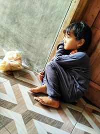 Side view of boy sitting at home