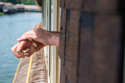 Midsection of man holding stick in water