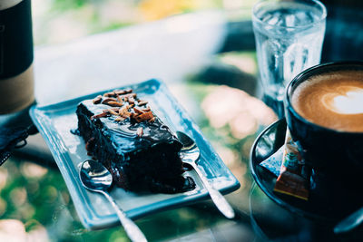 Close-up of cake by coffee cup in plate on table