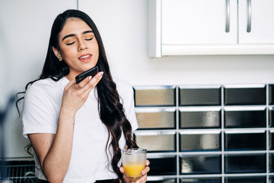 Young woman holding ice cream at home