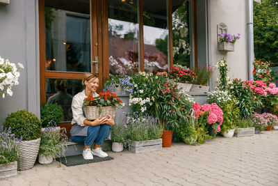 Rear view of woman holding potted plant