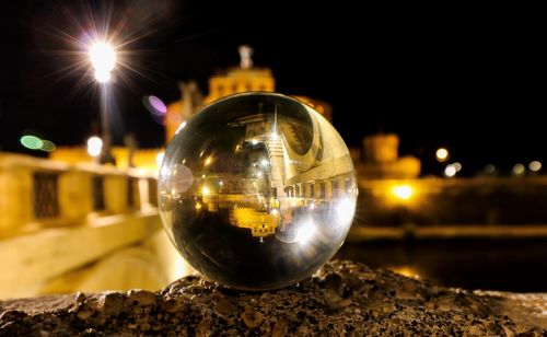 Close-up of illuminated crystal ball on street at night