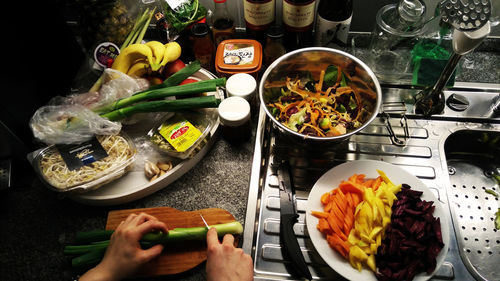 Cropped image of hand cutting vegetables in kitchen