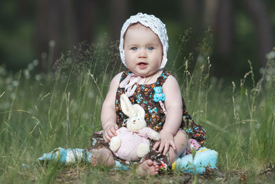 Portrait of cute girl with arms raised standing on field