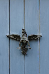 Close-up of statue against blue door