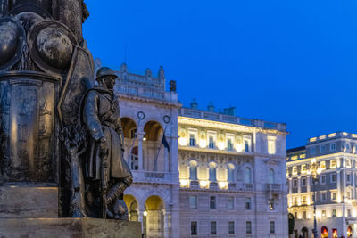 Low angle view of statue in city against clear sky