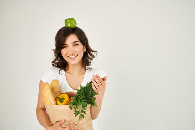 Portrait of smiling young woman against white background