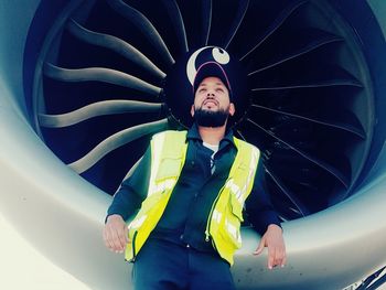 Engineer standing against airplane engine