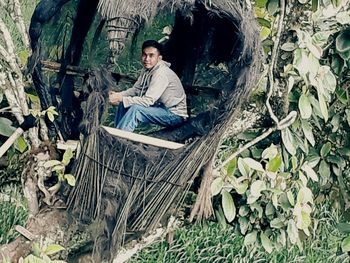 Full length of young man sitting outdoors