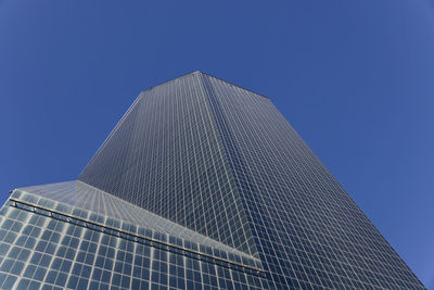 Low angle view of skyscraper against clear blue sky