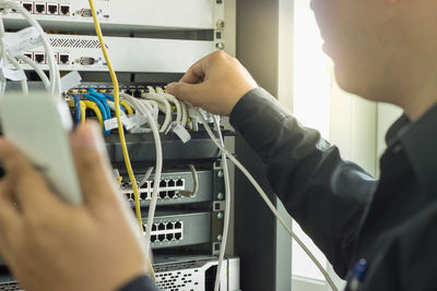 Cropped image of man connecting usb plug on network server