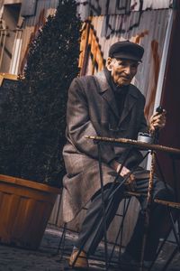 Man holding camera while standing outdoors