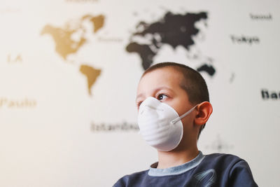 Close-up portrait of boy standing against wall