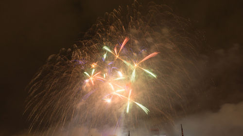 Low angle view of firework display at night