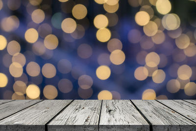 Defocused image of illuminated lights on wooden table