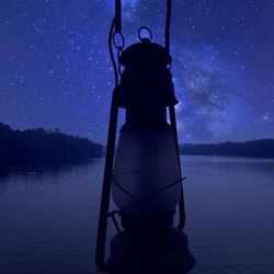 Man in lake against sky at night