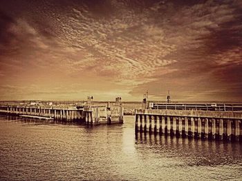 Pier on sea at sunset