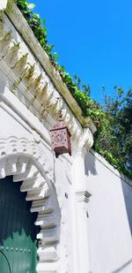 Low angle view of cross by building against sky