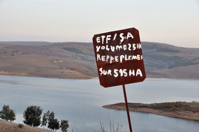 Information sign on landscape against sky