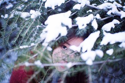 High angle portrait of girl standing by snow covered tree