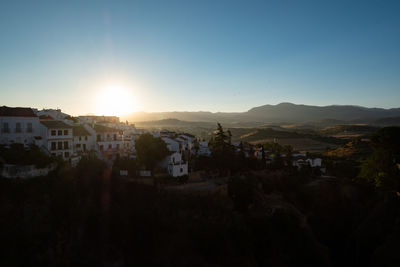 Buildings in town against sky during sunset