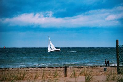 Sailboat sailing on sea against sky