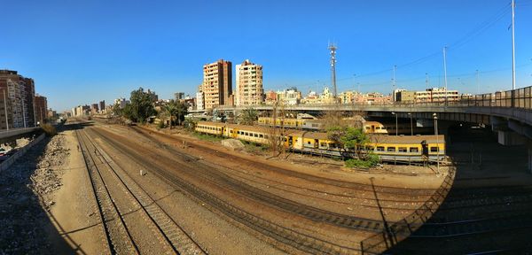 Panoramic view of railroad tracks in city against clear sky