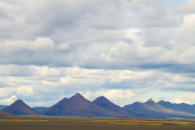 Scenic view of mountains against cloudy sky