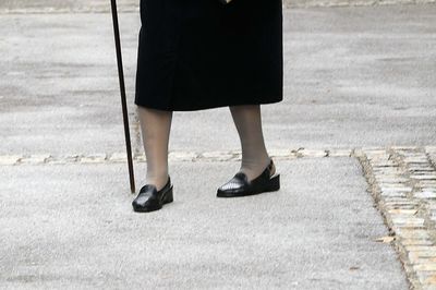 Low section of woman standing on footpath