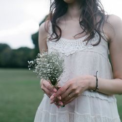 Close-up mid section of woman holding flowers