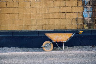Old yellow wheelbarrow in the street in he construction
