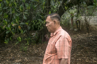 Senior man standing in forest