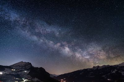 Scenic view of snowcapped mountains against sky at night