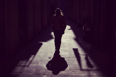 Rear view of man walking on footpath