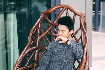 Thoughtful young man looking down while sitting in hammock