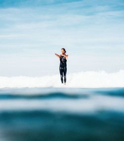 Full length of man standing in sea against sky