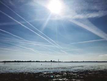 Scenic view of sea against cloudy sky on sunny day