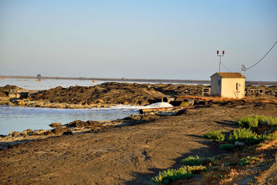 Scenic view of beach by sea against clear sky