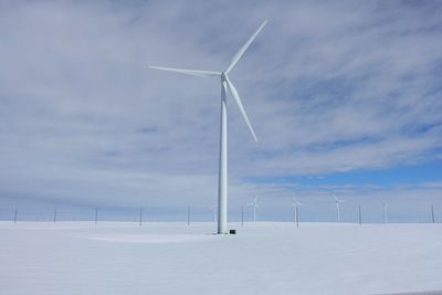 Windmill on field against sky