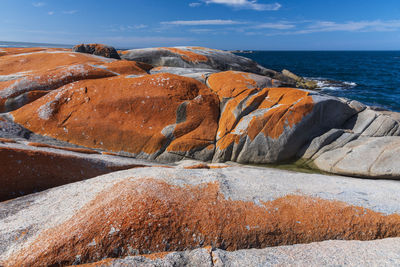 Rock formations by sea against sky